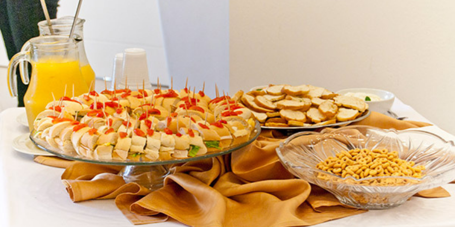 Foto mesa de petiscos com mini sanduíches, torradinhas e salgadinhos