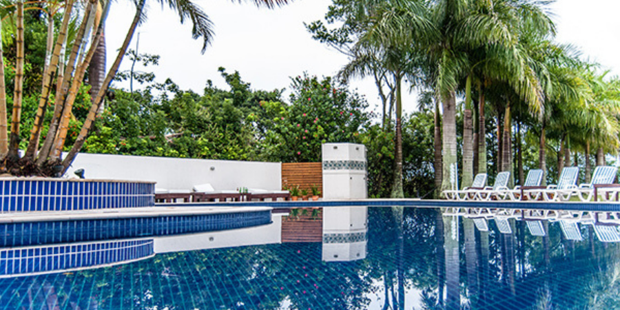  piscina do Hotel Torres da Cachoeira com cadeiras de sol e coqueiros ao redor